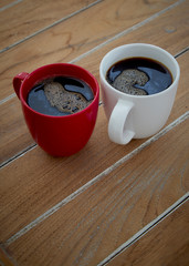 Two red and white mug coffee on wooden