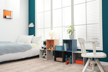 Modern child room interior with comfortable bed near window