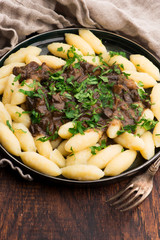 Freshly cooked, Polish traditional potato dumplings serving with mushroom sauce and fresh parsley