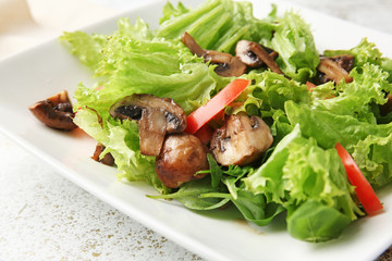 Plate with tasty mushroom salad on table, closeup