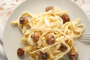 Plate with tasty cooked mushrooms and pasta on table, closeup