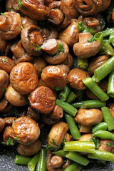 Frying pan with tasty cooked mushrooms and green beans, closeup