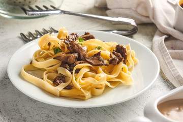 Plate with tasty cooked mushrooms and pasta on table
