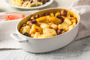 Baking dish with tasty cooked mushrooms and potato on table