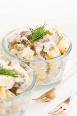 Salad rasols made of herring, cucumber and potato, dressed with mayonnaise and mustard