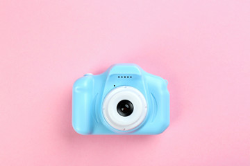 Light blue toy camera on pink background, top view