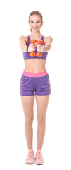 Sporty young woman training with dumbbells against white background