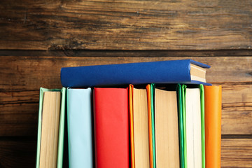 Stack of colorful books on wooden background