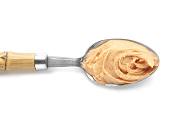 Spoon with tasty peanut butter on white background