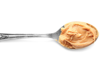 Spoon with tasty peanut butter on white background