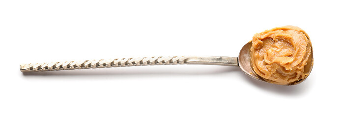Spoon with tasty peanut butter on white background