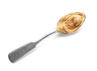 Spoon with tasty peanut butter on white background