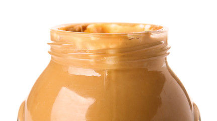 Tasty peanut butter in jar on white background