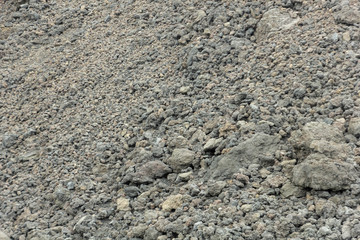 Background of stones on the black ground of Lava of a Etna Volcano