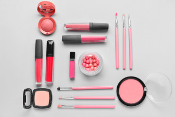 Set of decorative cosmetics and brushes on light background
