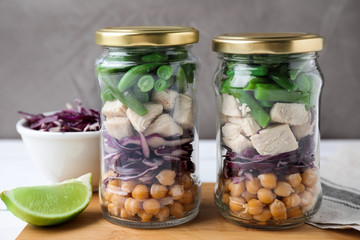 Glass jars with healthy meal on wooden table