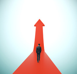 Businessman walking on red arrow