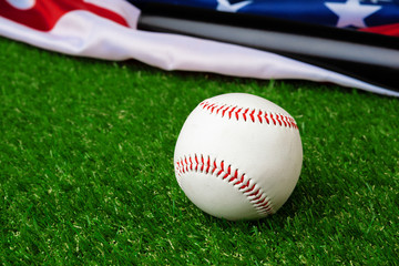 Baseball bat and ball with american flag on grass