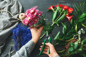 Fototapeta na wymiar Female florist making beautiful bouquet at table
