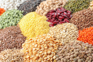 Different types of legumes and cereals as background, closeup. Organic grains