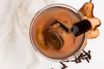 Dried fruits compote in glass on white