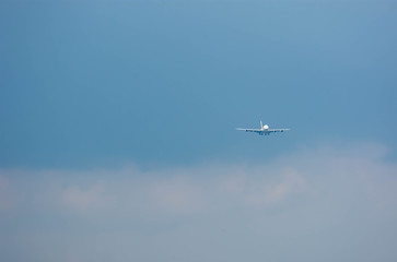A landing airplane approaching an airport with blue sky background