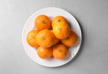 Fresh ripe tangerines on grey table, top view