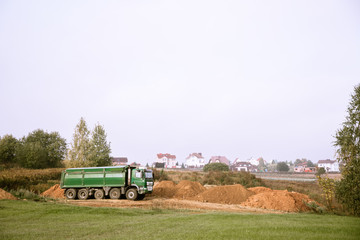 Obraz premium A large 70-ton dump truck brought sand to a new construction site to add land