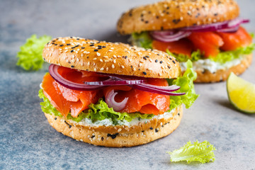 Bagels with cream cheese, smoked fish, red onion and lettuce, copy space.