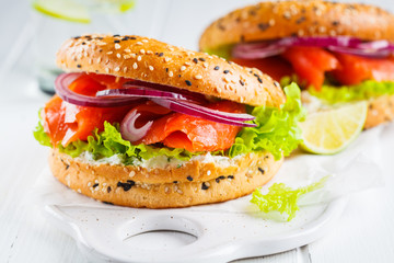 Bagels with cream cheese, smoked fish, red onion and lettuce.