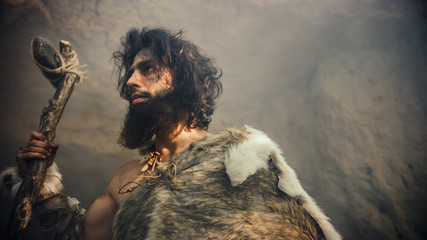 Primeval Caveman Wearing Animal Skin Holds Stone Tipped Hammer Comes out of the Cave and Looks into...