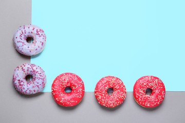 Sweet tasty donuts on color background