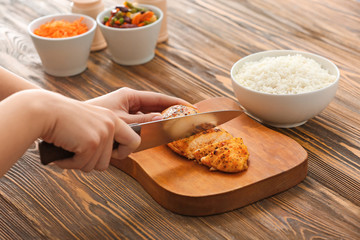 Woman preparing tasty rice with chicken