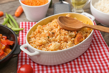 Dish with tasty rice on wooden table