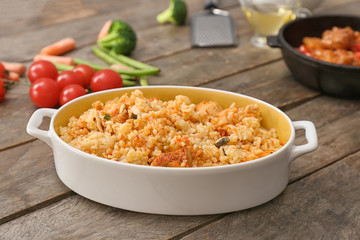 Dish with tasty rice on wooden table