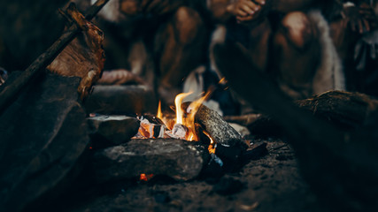 Close-up of Tribe Prehistoric Hunter-Gatherers Trying to Get Warm at the Bonfire, Holding Hands...