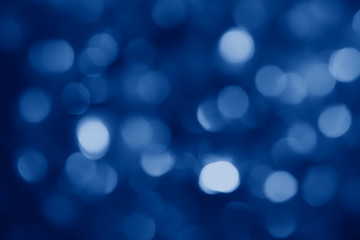 Fototapeta na wymiar abstract blurred circular bokeh lights background toned in trendy Classic Blue color of the Year 2020