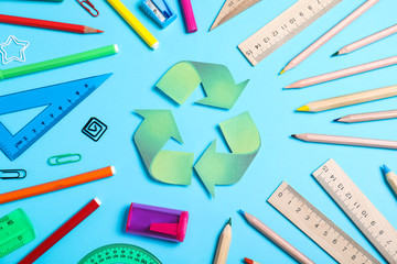 Recycling symbol, plastic and wooden stationery on light blue background, flat lay