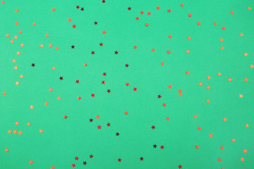 Falling red confetti on green background. Festive, Christmas, holiday, celebration.