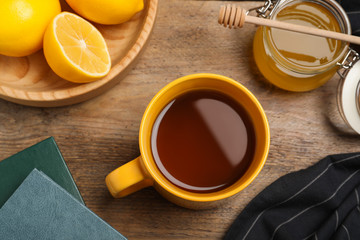 Tea with honey and lemon on wooden table, flat lay