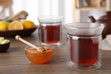 Delicious tea with honey on wooden table