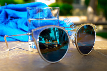 blue pareo and glasses on the background of green nature. A glass of water for thirst