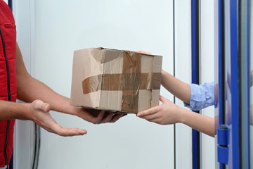 Courier giving damaged cardboard box to client, closeup. Poor quality delivery service