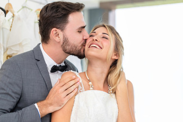 Bride and groom couple of Caucasian kiss and hug in wedding studio.