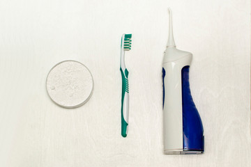 Morning oral care. Irrigator, tooth powder and toothbrush are on the table.