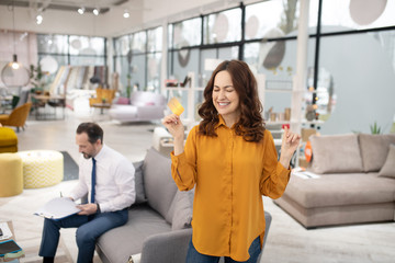 Dark-haired pretty customer feeling happy after making a good deal
