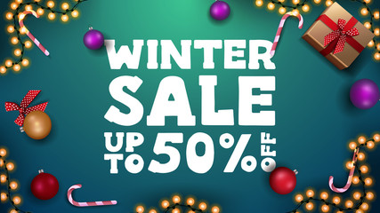 Fototapeta na wymiar Winter sale, up to 50% off, green discount banner with Christmas balls, candy canes, garland and gifts, top view