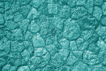 Wall made of old stones in cyan tone.