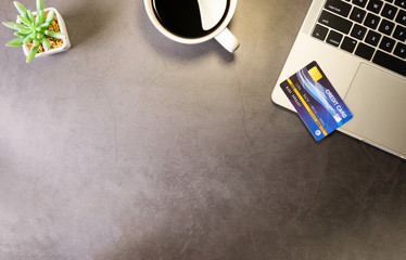 Flat lay, Workspace office desk table with laptop, coffee cup, credit card. Online shopping concept. Top view with copy space.