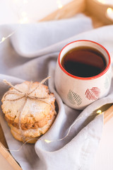 Fresh cookies and cup of tea on a wooden tray.